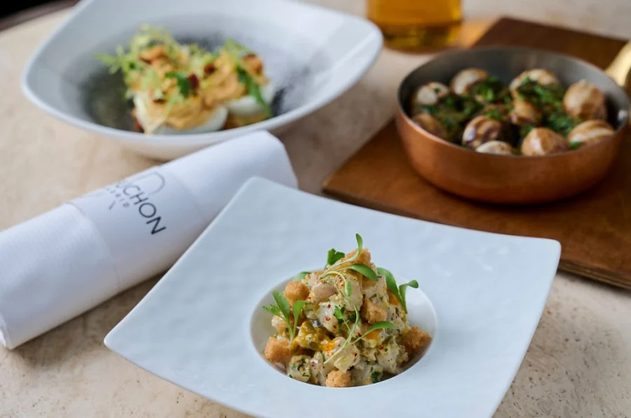 Platos de Le Bistrot Robuchon Madrid sobre una mesa con una servilleta del restaurante